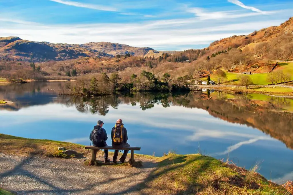 Two people sitting overlooking Redial water on a beautiful day
