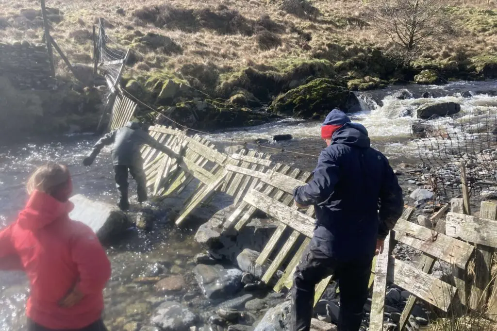 People in a river at High Borrowdale fixing a water gate