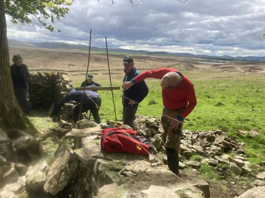 Checking the level of a dry stone wall during rebuild