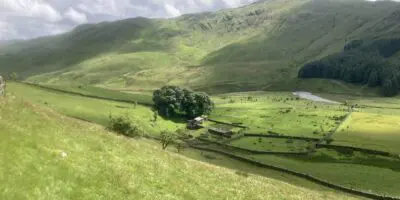 View down to the farmhouse in a green valley in High Borrowdale