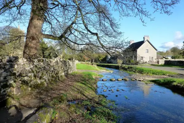 A lovely house by a blur river with stepping stones
