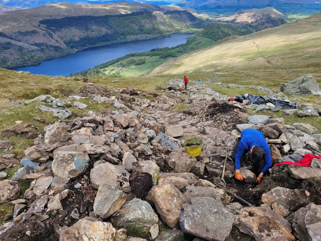 People repairing a path on the side of a mountain