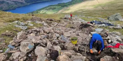 People repairing a path on the side of a mountain