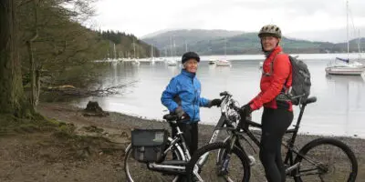 Two people on bikes looking happy