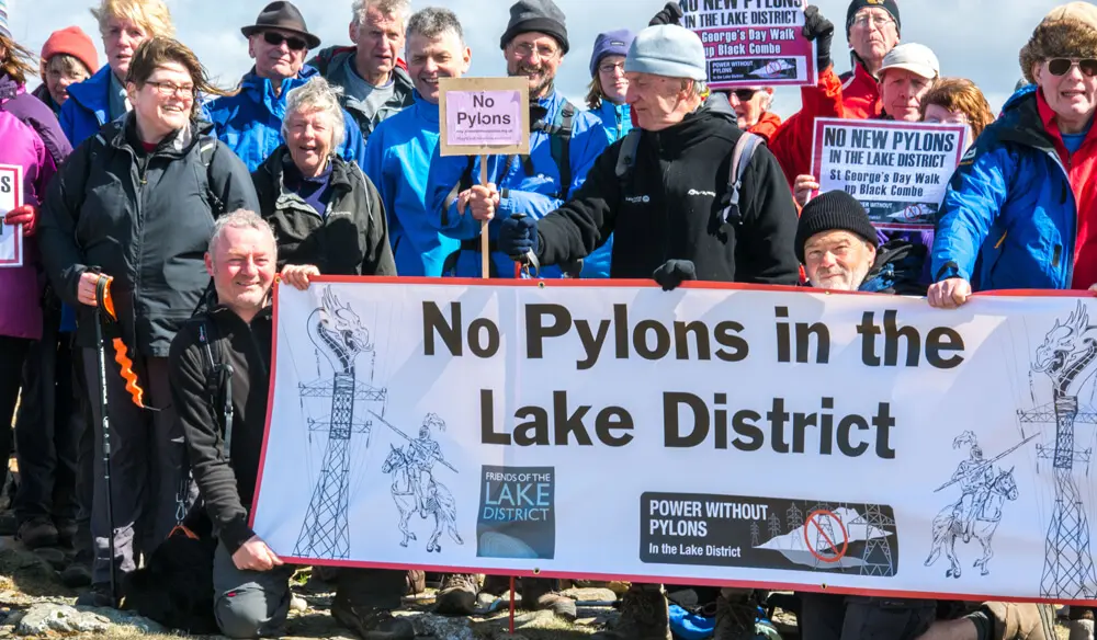 Protestors with a banner that says No pylons in the Lake District