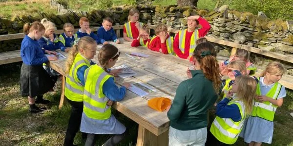 School children sitting around an outdoor table