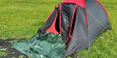 A red tent left on a hillside