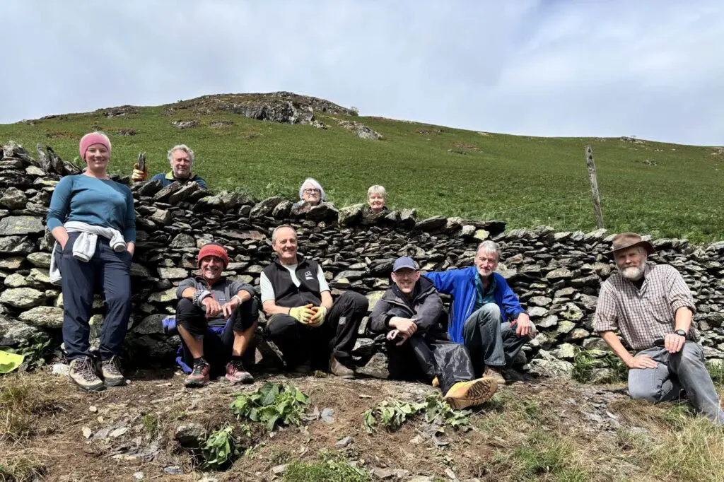 A group of people around a dry stone wall