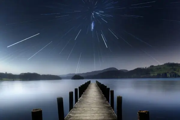 A jetty protruding into water under a night sky