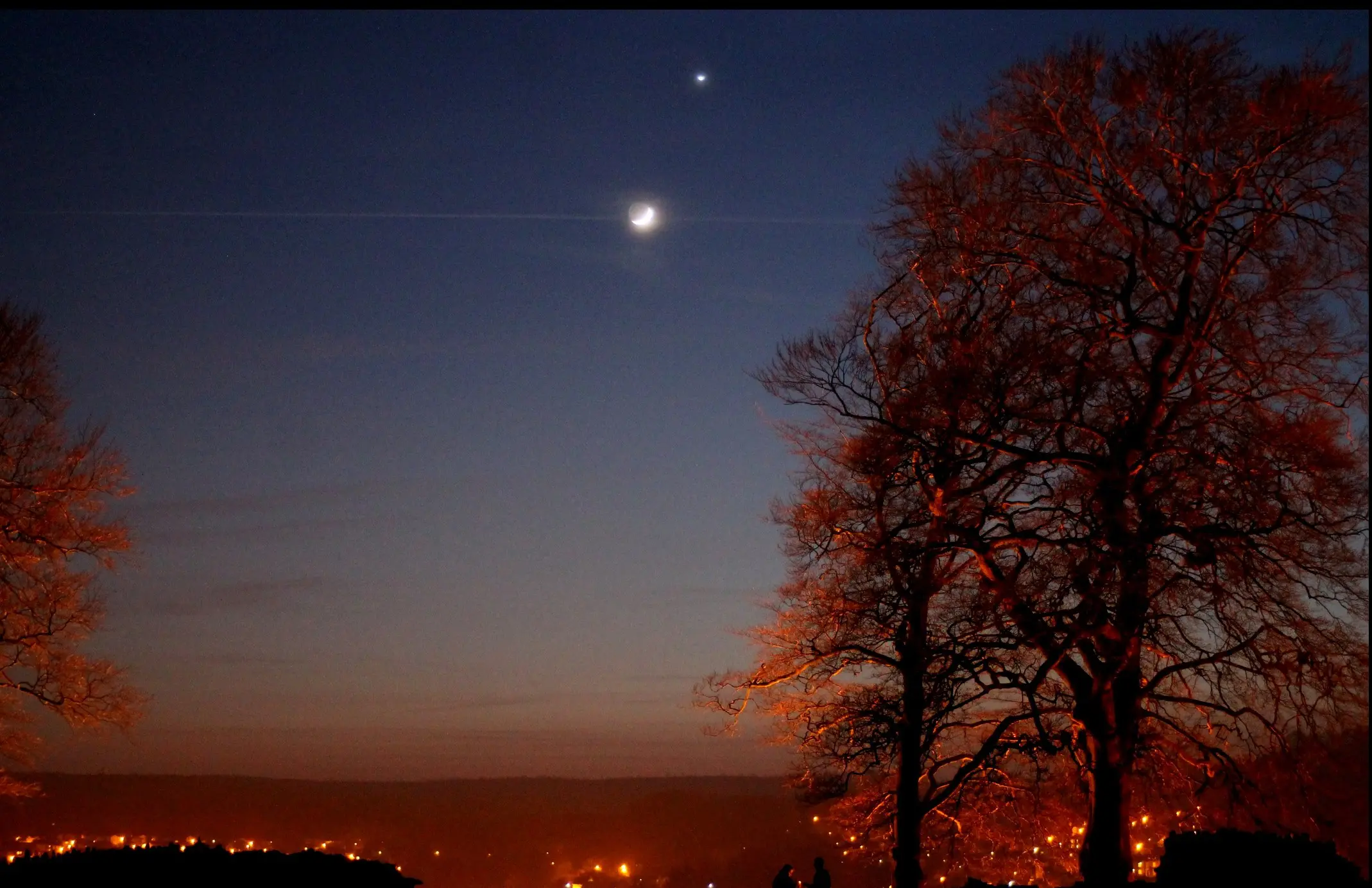 A night time view of the sky with the moon