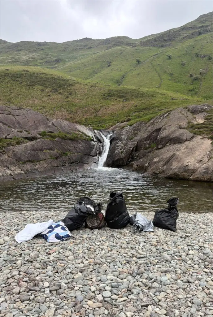 Bags of rubbish in front of the waterfall and tarn at Buckstone's Jump, Rydal, May 2026