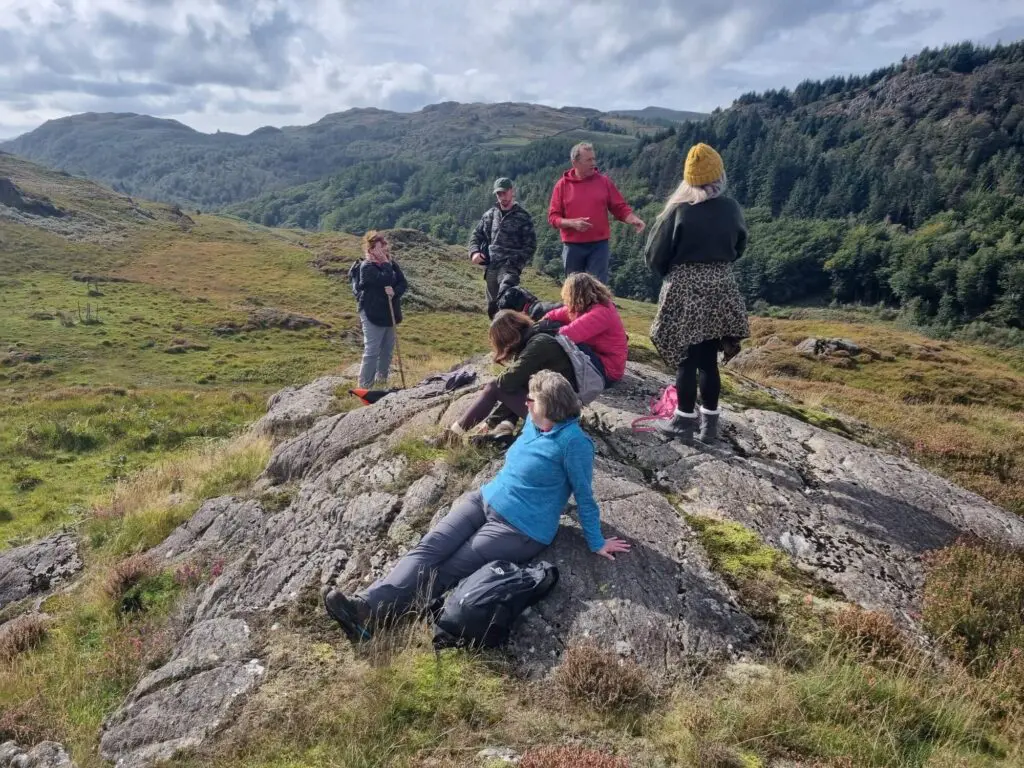 people sitting looking at a lovely hilly landscape