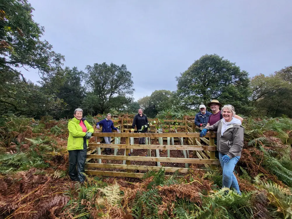 Group of volunteer next to tree enclosure