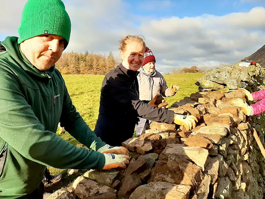 Group of 4 volunteers building a dry stone wall