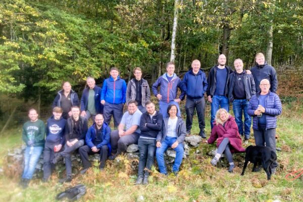 A large group of people gathered by a wood