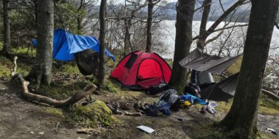 Tents and rubbish left by a lake