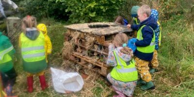 Children making a large bug hotel