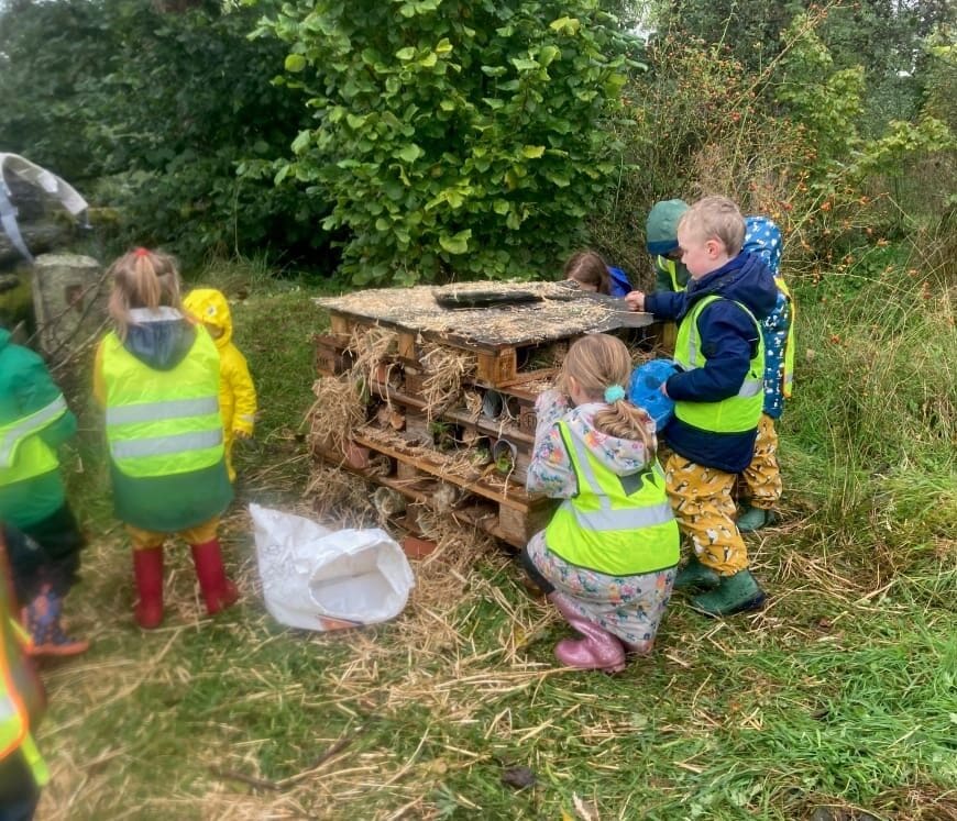 Children making a large bug hotel